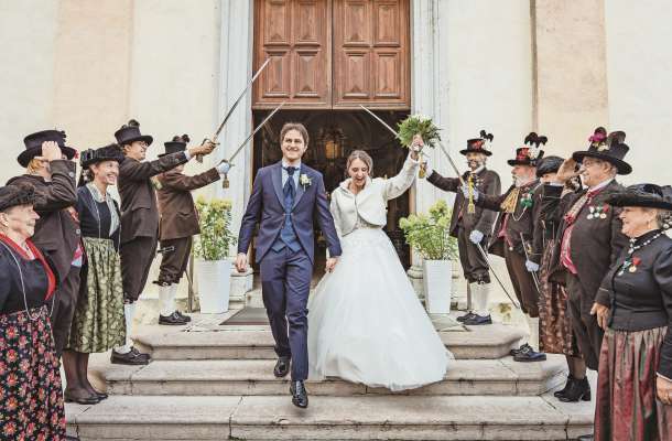 Filippo Huber e Alice Sartori fora de jeja, canche i s’à maridà, sote ra sciabeles de i Scizar. (Credito: Bandion.it)
