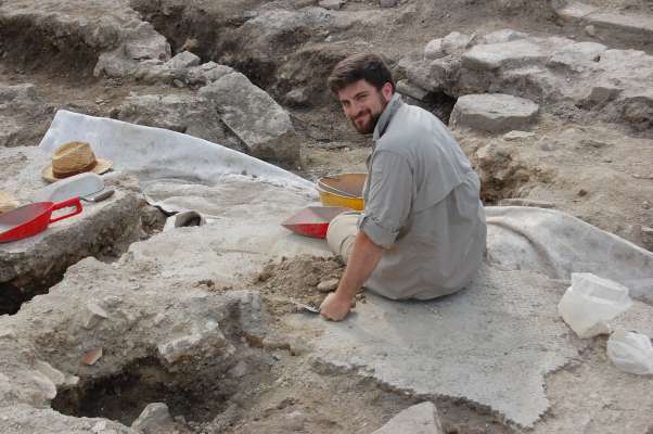 Albert Murer che puzenëia n mosaich de na vila romana a Aquilee tl 2016, sön na escavaziun dl’Université de Padova. foto:AM
